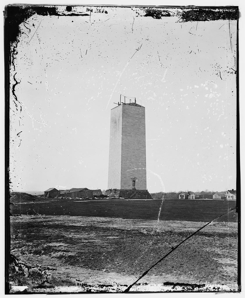 A photograph of the stalled Washington Monument. Construction materials are poking out of the unfinished shaft