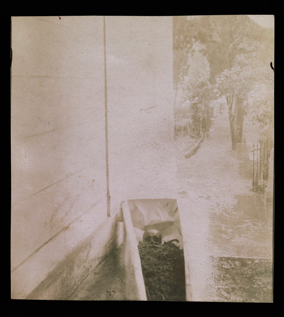 An image showing Smithson's open coffin next to the wall of the chapel. The coffin is open and the remains can be seen.