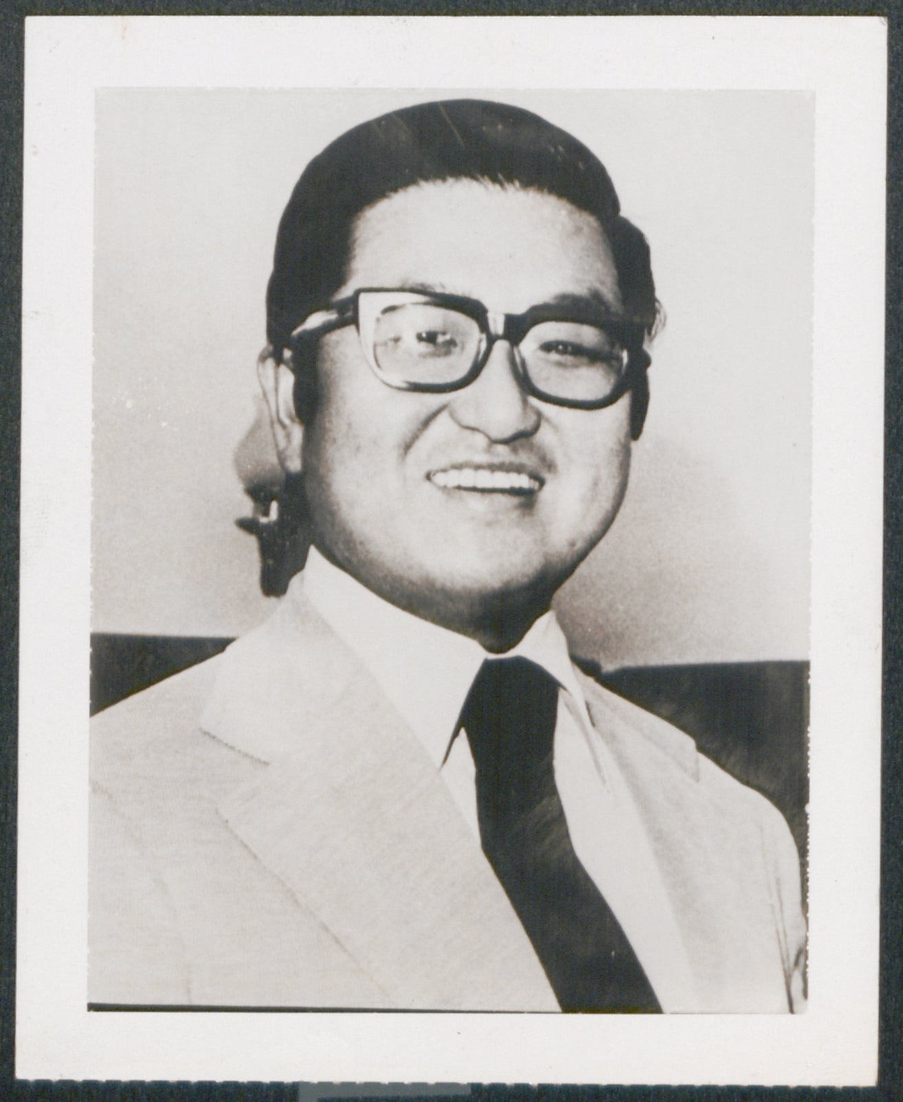 Tongsun Park smiles, wearing a suit