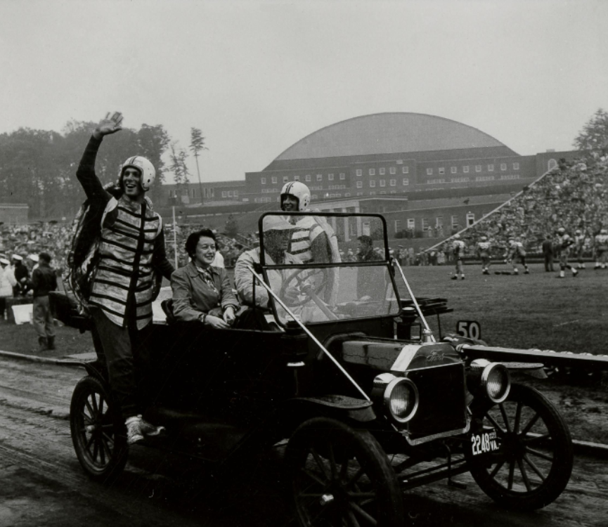 Students dressed as terrapin mascots ride in car around track, Byrd Stadium, University of Maryland, circa September 1955