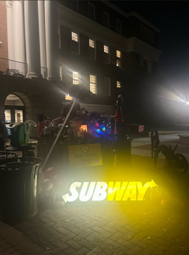 A photo of piled-up testudo offerings, including a lit Subway store sign