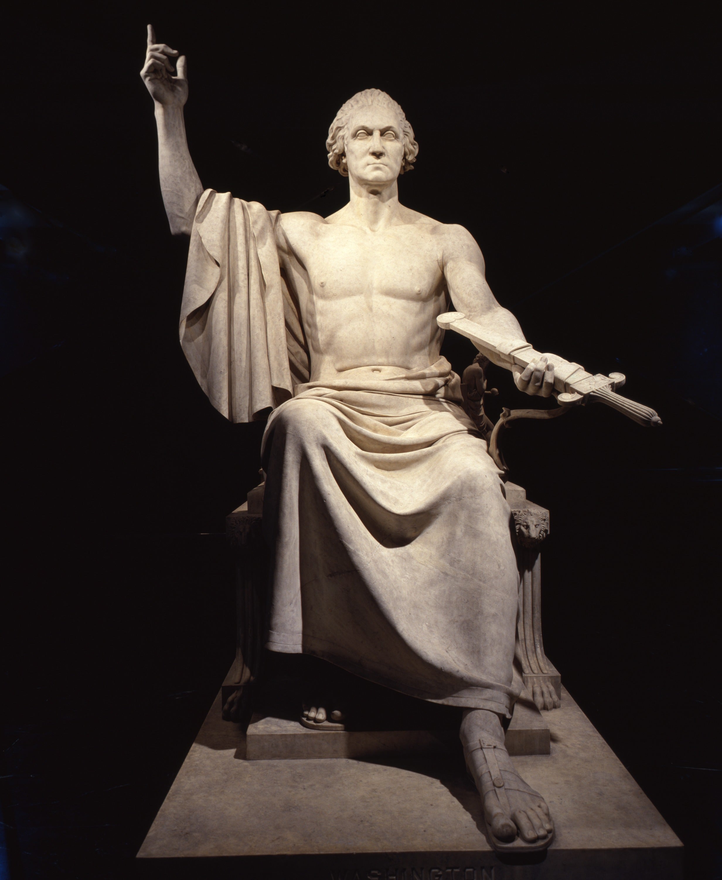 Stone carving of shirtless George Washington holding up his right hand.