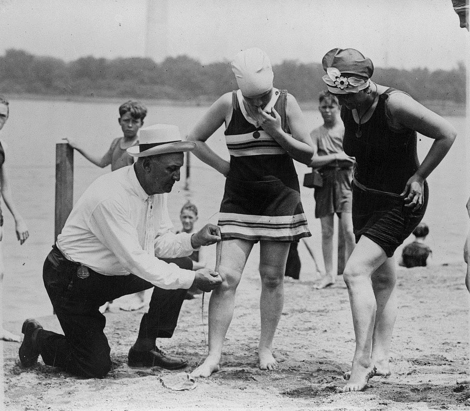 Officer Bill Norton measures a woman's suit to make sure it meets the six-inch requirement in 1922. (Photo source: Library of Congress) Officer Bill Norton measures a woman's suit to make sure it meets the six-inch requirement in 1922.