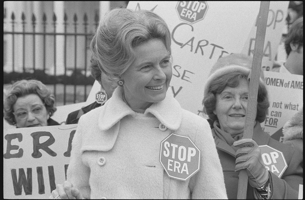 Activist Phyllis Schlafly wearing a "Stop ERA" badge, demonstrating with other women against the Equal Rights Amendment in front of the White House, Washington, D.C. Phyllis Schlafly, wearing a "STOP ERA" badge, protesting the Equal Rights Amendment in front of the White House in February 1977