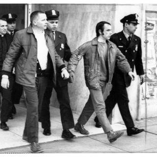 Four men are led out of a building by several police (source: Washington Area Spark) 