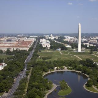 An aerial view of the National Mall showing the Washington Monument and the museums and other buildings in the distance
