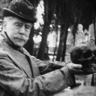 American consul William Bishop holding the skull of James Smithson up to the camera; side profile