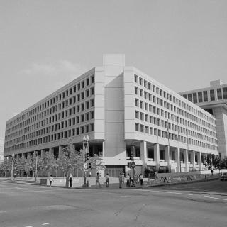 Black and white photo from 1977 of blocky concrete building in downtown D.C. intersection. 