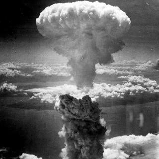 Black and white aerial photo of mushroom cloud from atomic bombing of Nagasaki, Japan in August 1945.