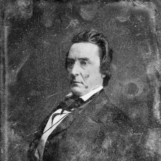 A seated portrait of a man, black and white