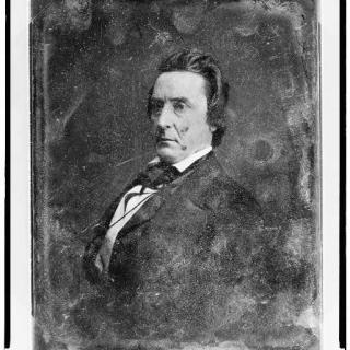 A seated portrait of a man, black and white