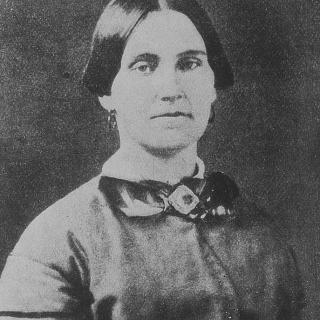 Portrait of Mary Surratt, a middle-aged woman in a dark dress, looking into the camera. Source: Wikimedia Commons