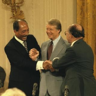 Anwar Sadat, Jimmy Carter and Menahem Begin shake hands after signing the Camp David Accords on September 17, 1978. (Source: National Archives)