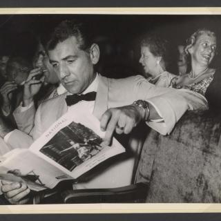 Leonard Bernstein reads playbill for West Side Story at the musical's premiere at the National Theater in Washington, DC on August 12, 1957. (Source: Library of Congress)
