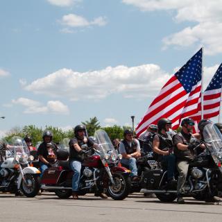 Rolling Thunder participants on their motorcycles with American flags in 2014. (Photo credit: Flickr user Robert Stankiewicz. Used via CC BY-SA 2.0 license.)