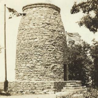 A stone tower flanked by two American flags