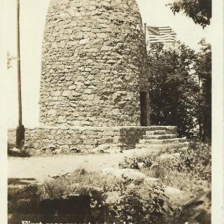 A stone tower flanked by two American flags