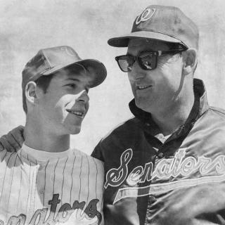 Ted Williams, wearing sunglasses, standing with with Senators player Joe Livotto, Jr. 