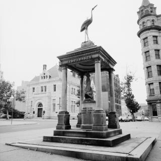 Black and white photo of statue with four pillars and a roof inscribed with "Temperance" on it.
