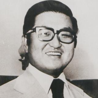 Tongsun Park smiles, wearing a suit