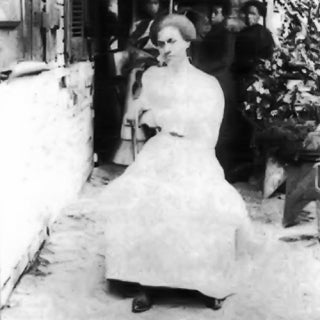 Old black and white photo of African American woman in white dress.