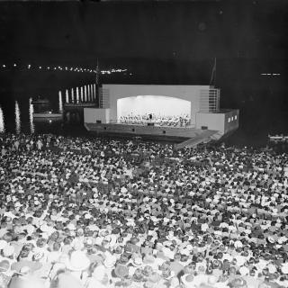 Hans Kindler conducts the NSO on the concert barge at the Watergate Amphitheatre in 1939.  (Photo Source: Library of Congress) https://www.loc.gov/pictures/item/hec2009013682/