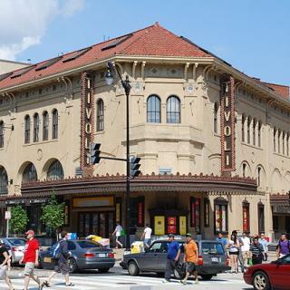 The revitalized Tivoli Theater in Columbia Heights, with tan walls and a red roof in an Italian architectural style. There is a large marquee, and signs with the word "Tivoli."