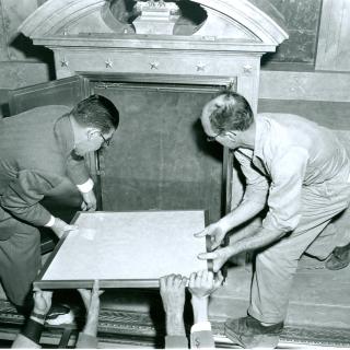 Two men placing the Declaration of Independence into the new display case at the National Archives (Source: National Archives)
