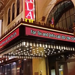 A closeup on the marquee of the Tivoli theatre. A vertical red sign reads "GALA" and the words on the marquee advertise ticket sales.