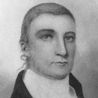 Black and white portrait of man with serious expression on his face.