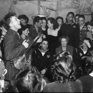 Pete Seeger performing at a party at the Congress of Industrial Organizations canteen in Washington DC in 1944, as First Lady Eleanor Roosevelt looks on. Credit: Library of Congress.