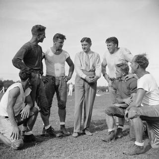 George Marshall, owner of the Washington Redskins, talks it over with some of his players, left to right: Wayne Millner, tackle, end, Charlie Malone, end,. Vic Carroll, Tackle,. George Marshall, Bill Young, Tackle, Ed Michaels, Guard, Jim Garber, Tackle,. 9/11/37