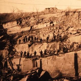Quarry workers on a rocky hillside.