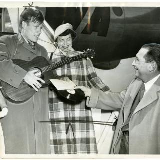 From left to right, Jimmie Dodd and his wife, Ruth, are presented with a record of "Washington" by James H. Simon.