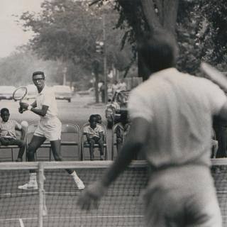 Arthur Ashe and Charlie Pasarell playing tennis in the street.