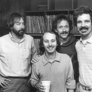 WHFS deejays Damian Einstein (far right) and Weasel (front) pose with musician Jesse Colin Young (second from right) and an unidentfied record executive (far left) at WHFS headquarters in Annapolis, MD in 1983.  (Photo source: Handout photo/Steve King).