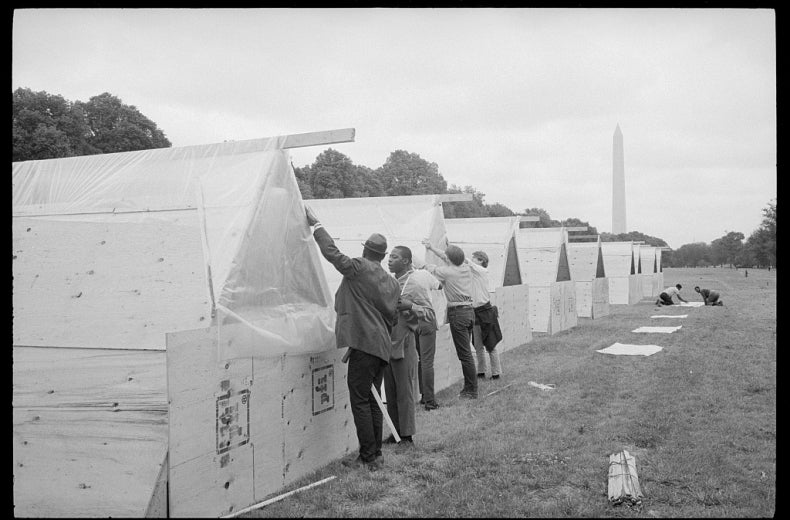 A row of tents with Washington Monument in the background.
