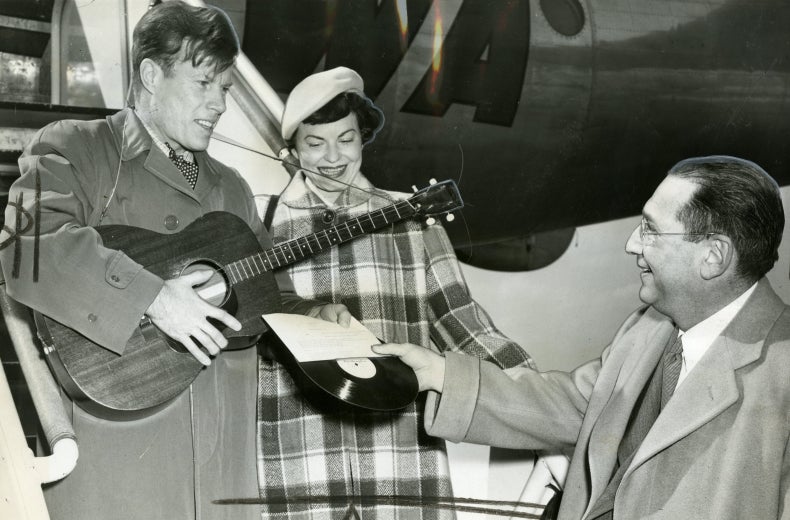 From left to right, Jimmie Dodd and his wife, Ruth, are presented with a record of "Washington" by James H. Simon.