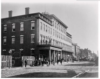 Black and white photograph of the 100 Block of North Fairfax Street, taken 1861-1865. (Photo source: Wikimedia Commons.)