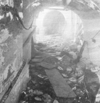 A passageway below the capitol is littered with debris- stone chunks and wooden planks.