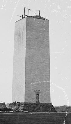 A photograph of the stalled Washington Monument. Construction materials are poking out of the unfinished shaft