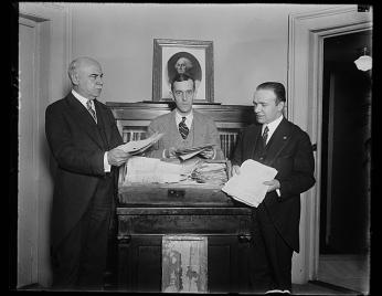 Black and white photo of Woodhouse presenting papers to Clerk of the House of Representatives