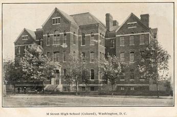 A postcard with a black-and-white photo depicting M Street School, an imposing brick building surrounded by trees
