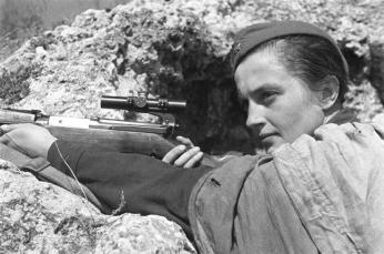 Pavlichenko pointing her rifle in a trench