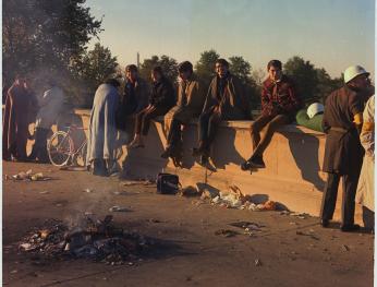 Protesters sit on the wall around their bonfire after spending the night at the Pentagon's mall entrance