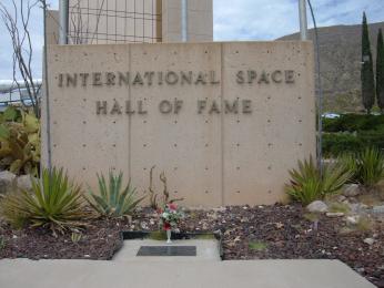 Photo of bronze plaque on the ground below the entry sign of the International Space Hall of Fame.