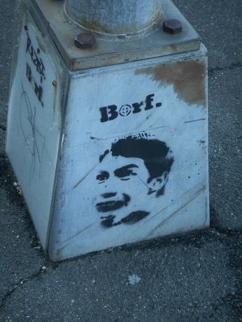 a spray-painted BORF face on a lamppost