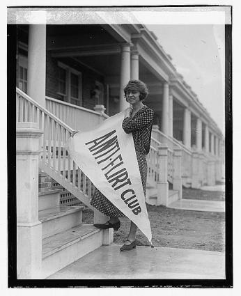 Alice Reighly, founder of the Anti-Flirt Club, holds an "Anti-Flirt" banner