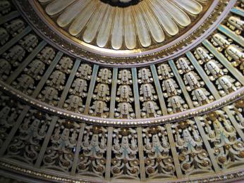 The ceilings of the renovated Tivoli, reflecting its past as a grand movie theater. The ceilings of the interior of the Tivoli. There is a circle, with flower petal-like designs branching out. Two more rings that have similar intricate designs circle it.