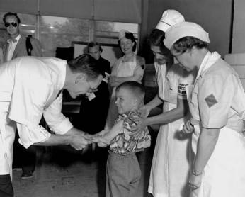Randall Kerr receives Polio vaccine Dr. Richard Mulvaney administers the trial Polio vaccine to Randall Kerr with two nurses looking on